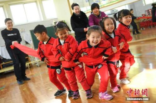 资料图:幼儿园内,老师、家长们与孩子们互动游戏。 武俊杰 摄 点击进入下一页